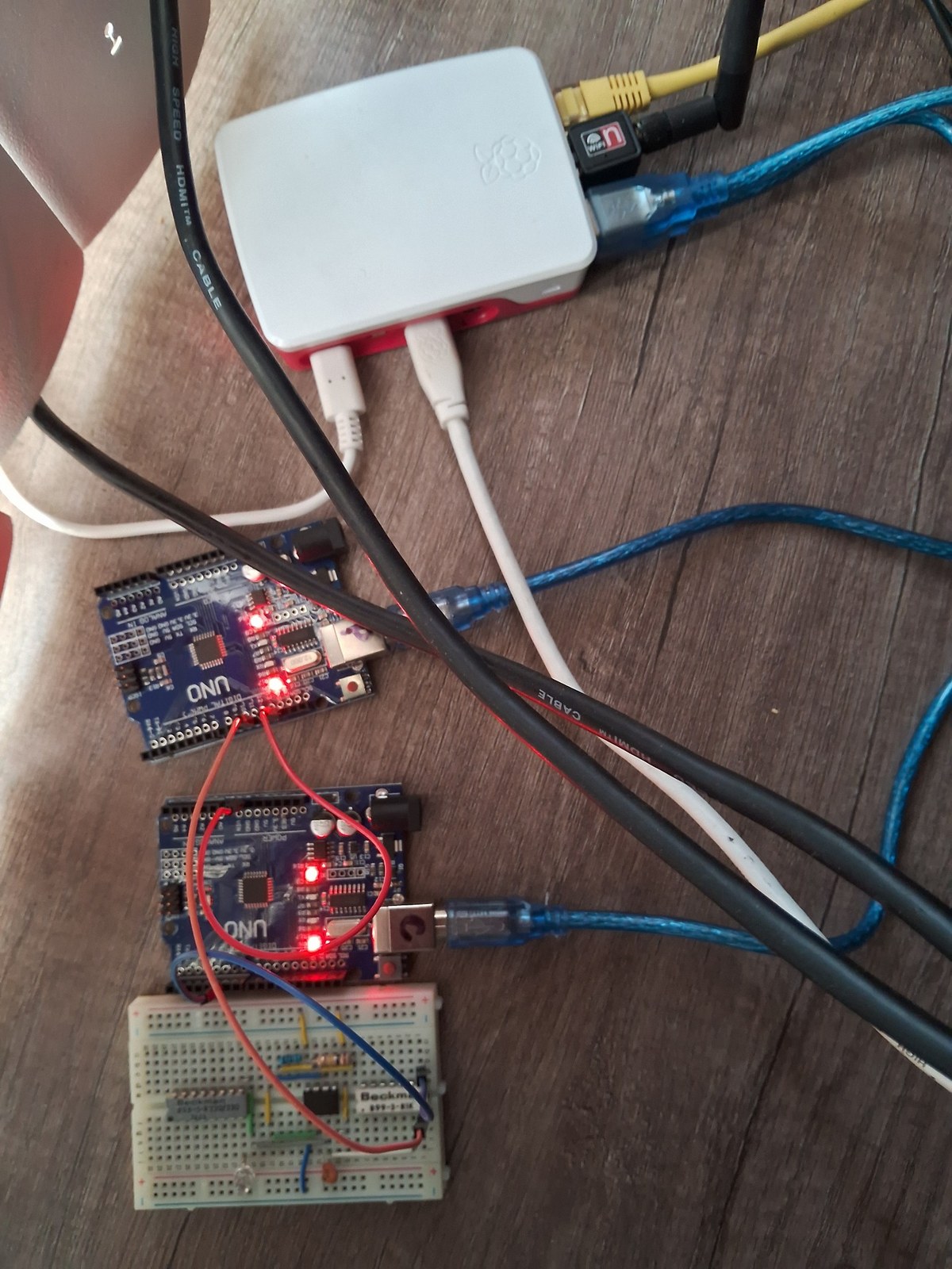Wider A8 Primary physical rig view with Arduino boards, breadboard interface area and Raspberry Pi host.